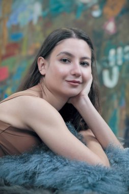 Açık kahverengi iç çamaşırlı, uzun dalgalı saçlı güzel bir kızın portresi.