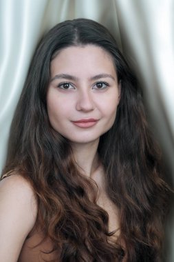 Kahverengi iç çamaşırlı, uzun siyah saçlı, güzel, kahverengi saçlı bir kadın.