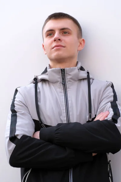 Portrét Mladého Muže Lehkém Pozadí Sportovním Oblečení Pro Mládež Bundě — Stock fotografie
