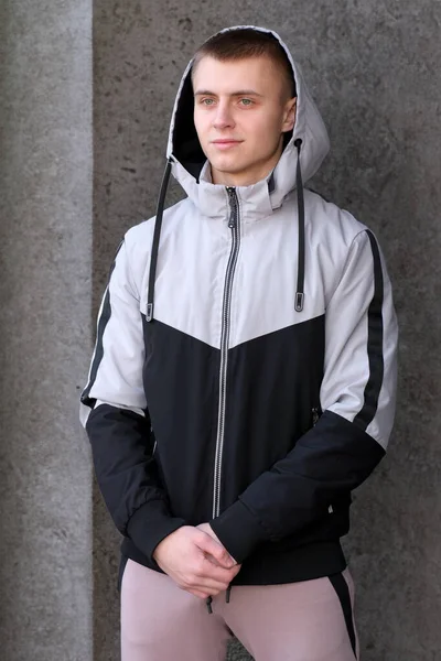 一个穿着青年运动服和夹克的深色背景的年轻人的画像 — 图库照片