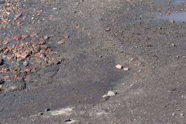 Bir yaz günü yağmurdan sonra şehirde hasar gören kaldırımlar, çukurlar ve çukurlar