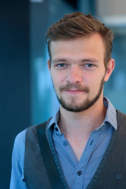 Sıcak bir yaz gününde, yeleğinde küçük sakallı ve bıyıklı yakışıklı bir adamın sokak portresi.