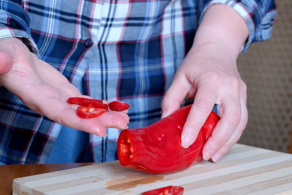 Mãos Uma Mulher Idosa Cortam Pimentas Vermelhas Exibem Nas Cozinha — Fotografia de Stock