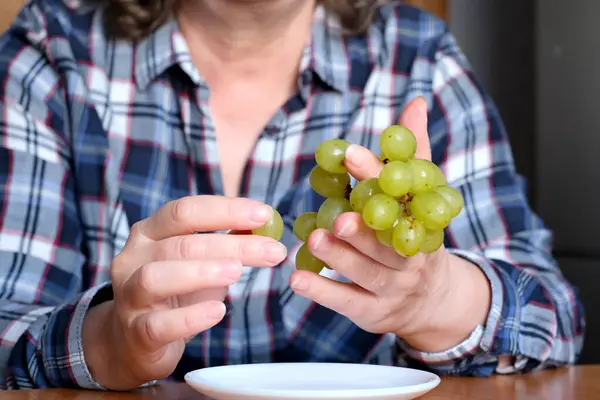Ręce Starszej Kobiety Trzymają Małą Szczotkę Białych Winogron Bez Nasion — Zdjęcie stockowe