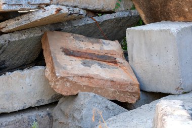 Şehirdeki bir atık sahasında eski yapı taşları ve levhalar, çevresel çizimler, doğa koruma