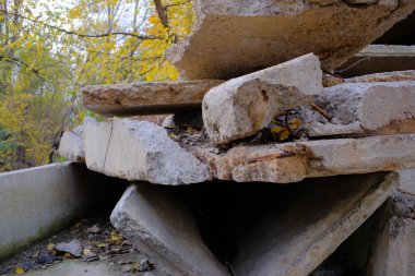 Büyük inşaat döküntüleri, beton döküntüler ve bloklar şehir sınırlarında uzanıyor ve sonbahar bulutlu bir günde çevreyi kirletiyor.