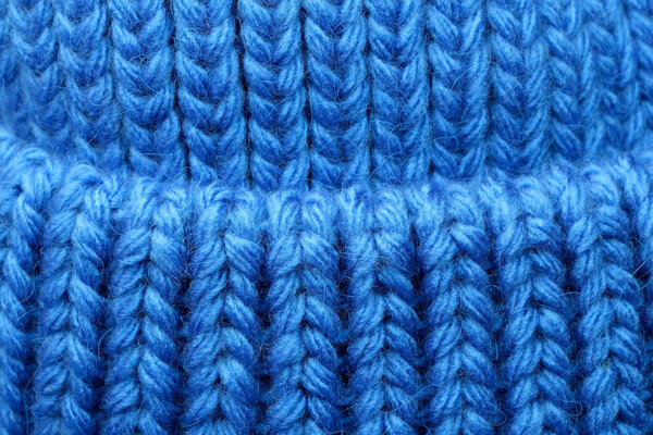 Textile blue background large knitted wool fabric, close-up background, macro photography