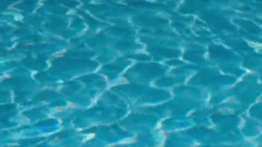 Parlak, güneşli bir günde, yüzme havuzunda dalgalanan suya yakın çekim
