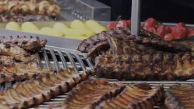 Cızırdayan kaburgalar ve canlı sebzeler bir yaz barbeküsünde ızgarada canlanıyor..