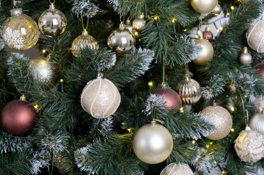 Altın ve gümüş süsler Noel ağacını süslüyor, usulca parlıyor.