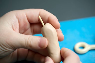 Eller yumuşak kilin kalıbını çalışma alanında araçlarla yaratıcı bir şekle sokar..