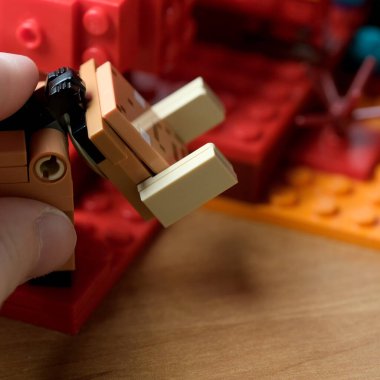 Bir el rengarenk bir figürü canlı yapı taşları arasında manipüle eder..