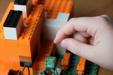 Bir çocuk renkli yapı taşlarıyla uğraşır, yaratıcı dünyalar yaratır..