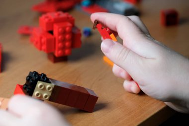 Eller parlak blokları yaratıcı şekiller ve yapılar oluşturarak birleştirir..