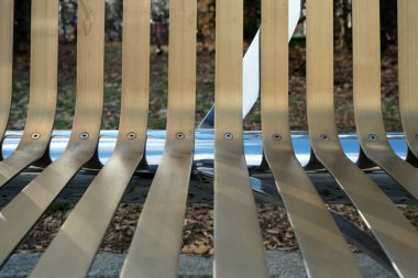 Tahta levhaların ustaca dizilişi, sakin bir parkta güneş ışığını yansıtır..