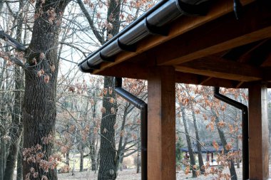 Baharın başında çıplak ağaçlarla çevrili kırsal bir ahşap pavyon..