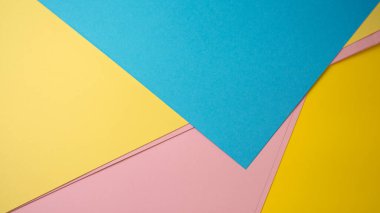 Parlak renkli kağıtlar örtüşüyor, neşeli renkler sergiliyor..