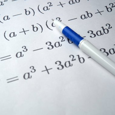 Çizgili kağıda kalemle yazılmış cebirsel denklemlerin yakın çekimi.