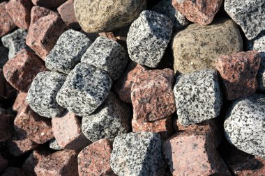 Doğal taşlar parlak güneş ışığı altında karmaşık dokular ve renkler sergiler.