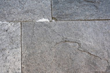 Yıpranmış gri taşlar güneş ışığı altında uyumlu bir şekilde kenetlenir..