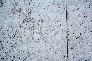 Textured concrete showcases natural patterns on a city sidewalk. clipart