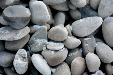 Çeşitli yuvarlak taşlar hafif bir tuz zerresiyle harmanlanmış olarak ışıldar..
