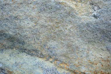 Karmaşık doku ve renkleri gösteren engebeli bir taşın yakın görüntüsü.