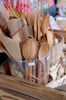 Çeşitli el yapımı ahşap çatal bıçaklar canlı bir pazarda vitrini dolduruyor..