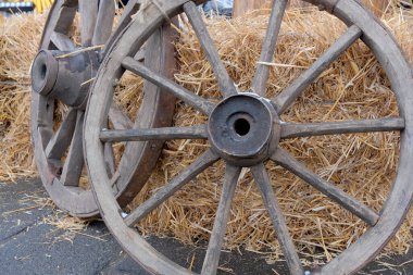 Eski ahşap tekerlekler yumuşak bir sonbahar gününde saman balyasına yaslanır..