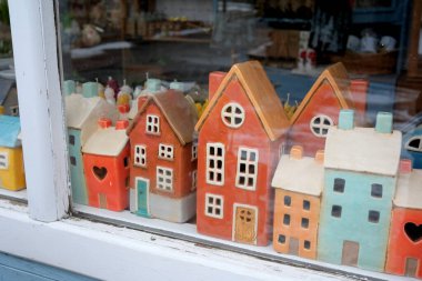 Penceredeki renkli seramik evler benzersiz şekiller ve tasarımlar gösterir.