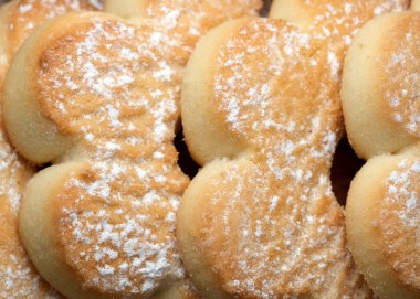 Kelebek silueti şeklinde taze pişmiş kurabiyelerle dolu enfes bir tepsi. Altın kabukları ve pudra şekerleri arkadaşlarıyla çay içerken tatlı anılarını davet ediyor..