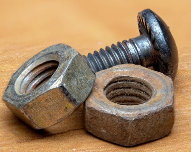 Metal fındıklar ve vida sıcak ahşap bir masa üstünde dinleniyor..