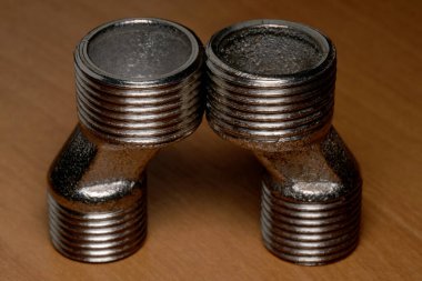 İki metal dirsek eklemi endüstriyel tasarımlarını vurgulayarak kusursuz bir şekilde bağlanır..