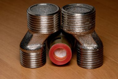 Üç metalik boru döşemesi cilalanmış ahşap üzerinde çarpıcı bir görüntü oluşturur..