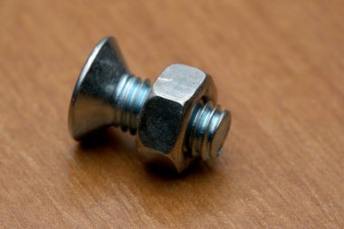 Metalik bir sürgüye yakın çekim ve ahşap bir yüzeyde ceviz, dokuları gösteriyor..