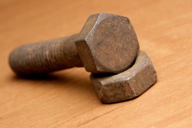 Paslı cıvatalar ve fındıklar ustalıkla ahşap bir masaya dizilmiş..