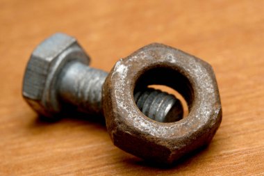 Yaş ve giysi belirtileri gösteren yıpranmış cıvata ve fındık yakın plan..