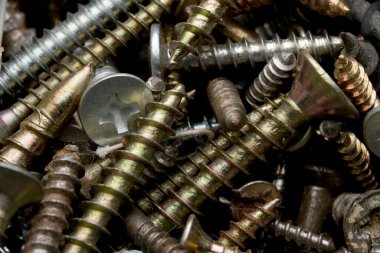 Çeşitli boyutlarda vidalar ve bitişler tezgahın üzerinde..