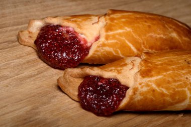 Zengin böğürtlen reçelli altın hamur işleri ahşap bir masada oturur..