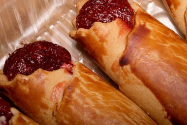 Sıcak rulo taze pişmiş, canlı böğürtlen reçeli ve davetkar bir tat..