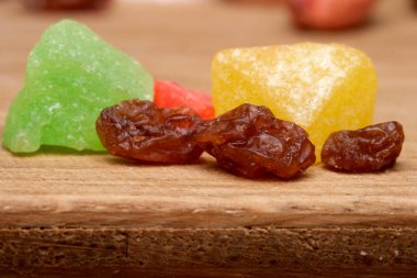 Parlak şeker ve kurutulmuş meyve parçaları ahşap bir yüzeyde ustalıkla duruyordu..