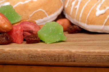 Parlak renkli şekerler ve kurabiyeler ahşap bir yüzeyde dinleniyor..