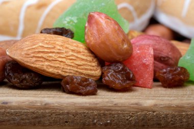 Parlak renkli şekerler ve karışık fındıklar ahşap üzerinde hoş bir gösteri oluşturur..