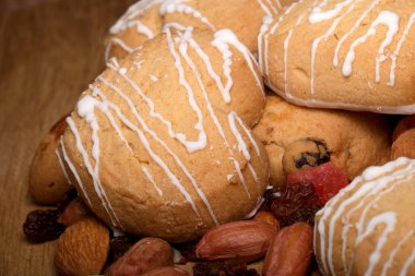 Kremalı lezzetli kurabiyeler çeşitli fındık ve kurutulmuş meyvelerin arasında oturur..