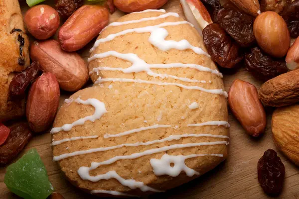 Kalp şeklinde bir kurabiye fındık ve kurutulmuş meyvelerle oturur..