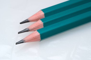 Üç renkli kalem parlak bir yüzeye oturmuş, yaratıcılığa hazır..