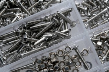 Kolay erişim için temiz kutularda metal vidalar ve fındıklar depolanır.