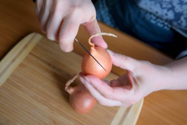 Elleri ustalıkla arpacık soğanlarını kesiyor..