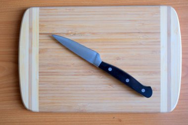 Parlayan bir bıçak, ahşap bir tahtanın üzerinde, aşçılık görevleri için hazırdır..