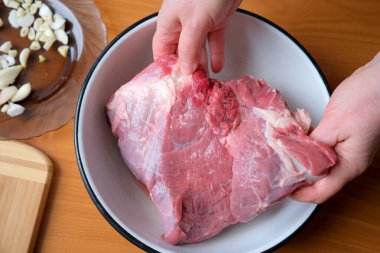 Eller, baharat ve pişirmeye hazır çiğ eti dikkatlice tutar..